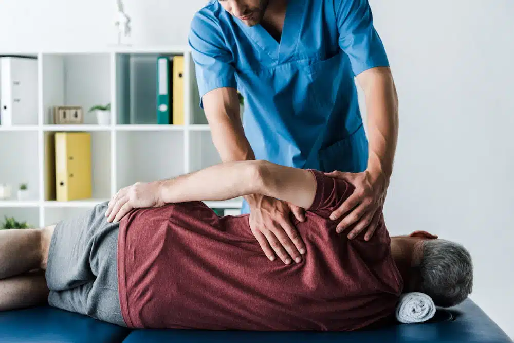 middle aged man receiving chiropractic therapy from auto accident