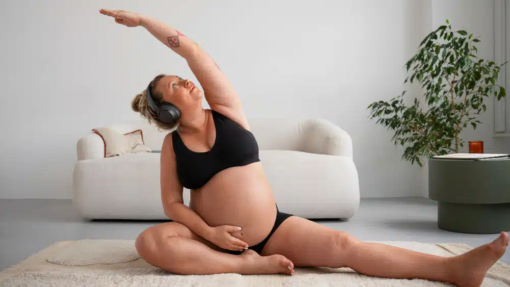 pregnant woman doing stretches on a mat