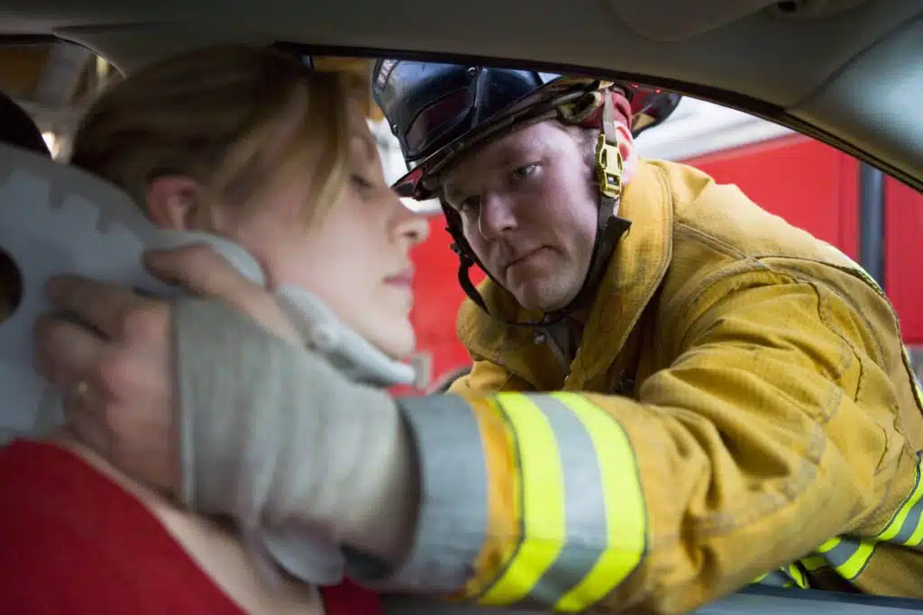 firefighters helping a woman after car accident